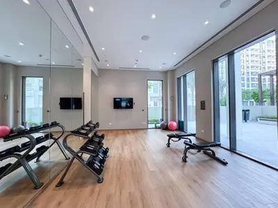 a gym with several treadmills in a room with windows at PVH - Charming 1 BR - Lotus Creek Beach in Dubai