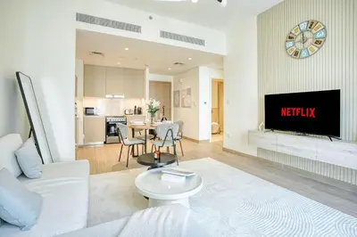 a living room with a couch a table and a tv at PVH - Charming 1 BR - Lotus Creek Beach in Dubai