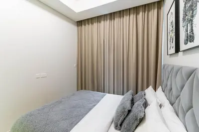 a bedroom with a bed and a curtain at Modern 1BR in Aykon City - Near Burj Khalifa & Canal in Dubai