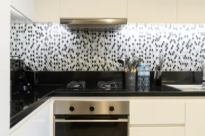 a kitchen with a black and white patterned wall at Modern 1BR in Aykon City - Near Burj Khalifa & Canal in Dubai