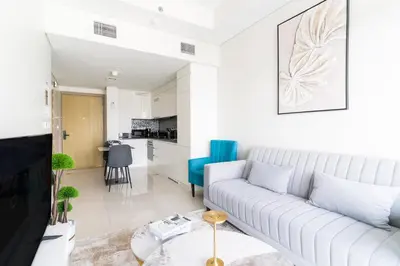 a white living room with a couch and a table at Modern 1BR in Aykon City - Near Burj Khalifa & Canal in Dubai