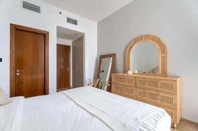 a bedroom with a bed and a dresser and a mirror at Luxury 2BR with Canal & Pool View Nr Downtown in Dubai