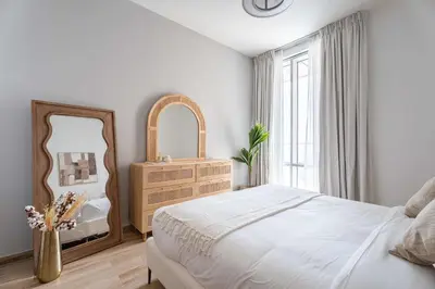 a bedroom with a bed and a mirror and a dresser at Luxury 2BR with Canal & Pool View Nr Downtown in Dubai