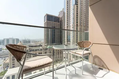 a balcony with two chairs and a table on a building at Luxury 2BR with Canal & Pool View Nr Downtown in Dubai