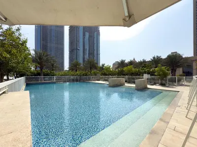 a large swimming pool with buildings in the background at Luxury 2BR with Canal & Pool View Nr Downtown in Dubai