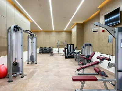 a gym with several treadmills and machines at Steps from Nakheel Mall and Monorail Station, Near Beach Clubs ,15 Mins to Downtown and Marina, The Palm Tower, Palm Jumeirah by Deluxe Holiday Homes in Dubai