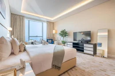 a hotel room with a large bed and a television at Steps from Nakheel Mall and Monorail Station, Near Beach Clubs ,15 Mins to Downtown and Marina, The Palm Tower, Palm Jumeirah by Deluxe Holiday Homes in Dubai