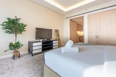 a bedroom with a large bed and a flat screen tv at Steps from Nakheel Mall and Monorail Station, Near Beach Clubs ,15 Mins to Downtown and Marina, The Palm Tower, Palm Jumeirah by Deluxe Holiday Homes in Dubai