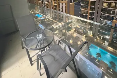 a table and a chair on the balcony of a building at Azizi Riviera 43 - Meydan by Golden Casa in Dubai