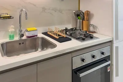 a kitchen counter with a sink and a stove at Azizi Riviera 43 - Meydan by Golden Casa in Dubai