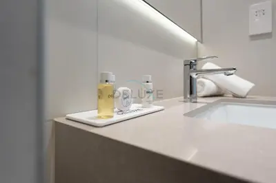 a bathroom counter with a sink and a soap dispenser at Steps from Marina Beach, AquaFun & The Walk, Mins to Bluewaters Island and Ain Dubai - La Vie, Jumeirah Beach Residence by Deluxe Holiday Homes in Dubai
