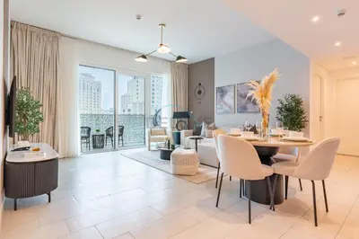 a living room with a table and chairs and a couch at Steps from Marina Beach, AquaFun & The Walk, Mins to Bluewaters Island and Ain Dubai - La Vie, Jumeirah Beach Residence by Deluxe Holiday Homes in Dubai