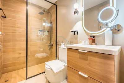 a bathroom with a toilet and a sink and a mirror at Seamless Access to Marina Mall, JBR Beach, Dining And Shopping Spots, Just A Few Meters from the Tram Station - Continental Tower, Dubai Marina by Deluxe Holiday Homes in Dubai