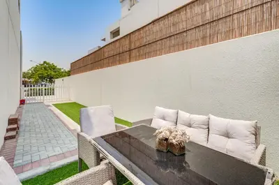 a patio with a table and chairs and a building at PVH - Chic 3BR Villa with Backyard - Albizia in Dubai