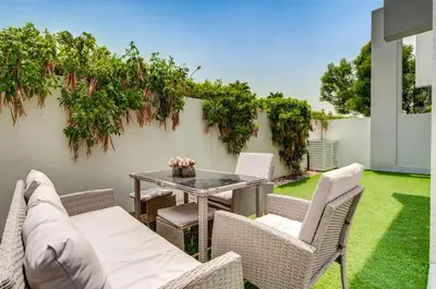 a patio with a table and chairs and a fence at PVH - Chic 3BR Villa with Backyard - Albizia in Dubai