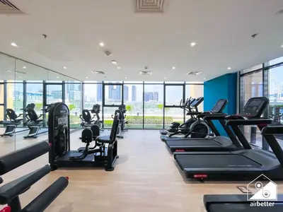 a gym with treadmills and elliptical machines at Amazing Studio in Meydan l Pool , Gym & Balcony in Dubai