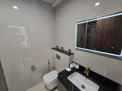 a bathroom with a toilet and a sink and a window at Stylish 1-Bedroom Apartment in Dubai