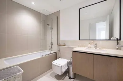 a bathroom with a toilet and a tub and a sink at Mahogany 17 - 2BR 10PAX - On the Boulevard Sea View in Dubai