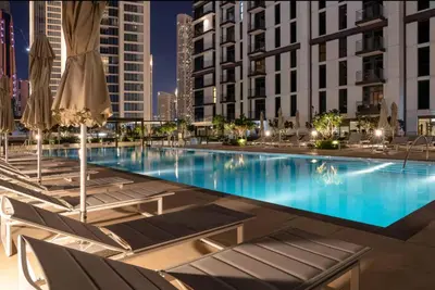 a large swimming pool with chairs and umbrellas at Mahogany 17 - 2BR 10PAX - On the Boulevard Sea View in Dubai