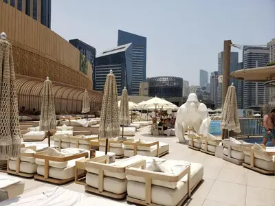 a patio with tables and umbrellas in front of a city at Deluxe 1 BR At Address Apartments Marina Mall by Primevanguard in Dubai