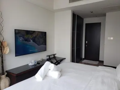 a bedroom with a white bed with a tv on the wall at Deluxe 1 BR At Address Apartments Marina Mall by Primevanguard in Dubai
