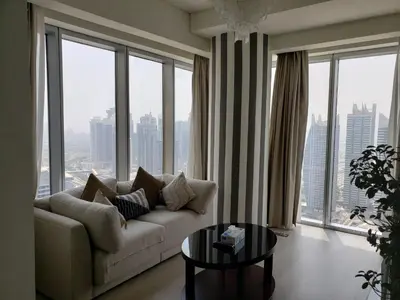 a living room with a couch and a table and windows at Deluxe 1 BR At Address Apartments Marina Mall by Primevanguard in Dubai