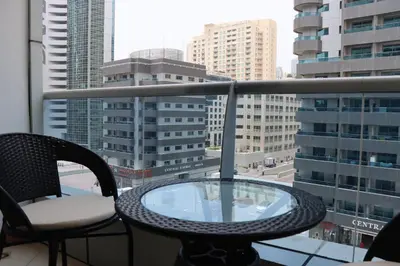 a balcony with a table and chairs and a view of a city at Dubai Marina 1BR with Balcony, Near Metro, Walk to JBR beach & Marina Promenade in Dubai