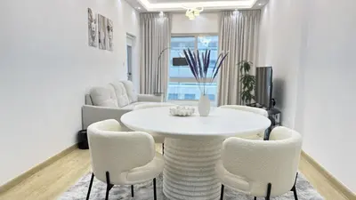 a white dining room with a white table and chairs at Dubai Marina 1BR with Balcony, Near Metro, Walk to JBR beach & Marina Promenade in Dubai