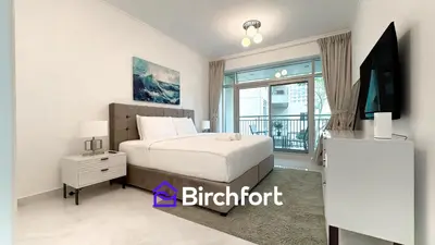 a bedroom with a bed and a tv and a window at Birchfort- Downtown Living with Burj Khalifa View in Dubai