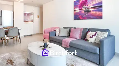 a living room with a blue couch and a table at Elegant Flat in Prime Location in Dubai