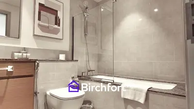 a bathroom with a shower and a toilet and a tub at Elegant Flat in Prime Location in Dubai