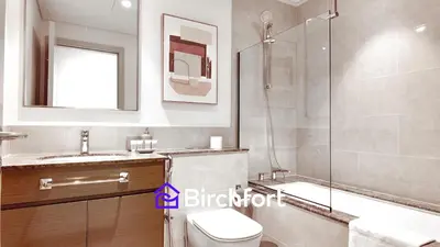 a bathroom with a shower and a toilet and a sink at Elegant Flat in Prime Location in Dubai