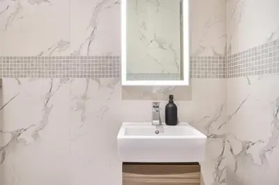 a white bathroom with a sink and a mirror at STAY BY LATINEM Luxury 2BR Holiday Home OPA 305 Near Downtown in Dubai