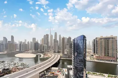 a view of a city with a bridge and buildings at FAM Living - 2BR Apartment with Burj & Canal Views at The Bay in Dubai