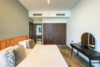 a bedroom with a large bed and a desk at 1BR City Escape l Canal & Skyline Views in Dubai