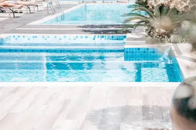 a swimming pool with blue water in a resort at 1BR City Escape l Canal & Skyline Views in Dubai