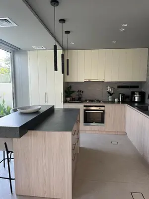 a kitchen with white cabinets and a black counter top at Luxury 4 Bedroom Villa The Springs Dubai in Dubai