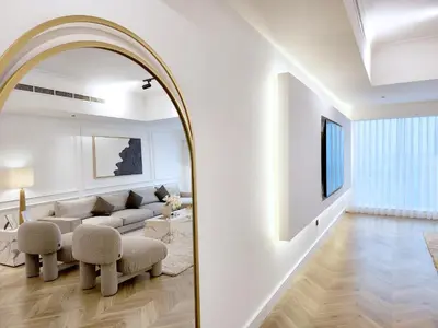a living room with a couch and a mirror at SOLARTE Luxe - New Large 2BR - Marina Promenade - Sea Views - Super King Bed & Workspace in Dubai