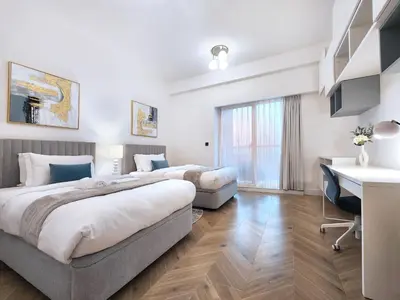 a hotel room with two beds and a desk at SOLARTE Luxe - New Large 2BR - Marina Promenade - Sea Views - Super King Bed & Workspace in Dubai