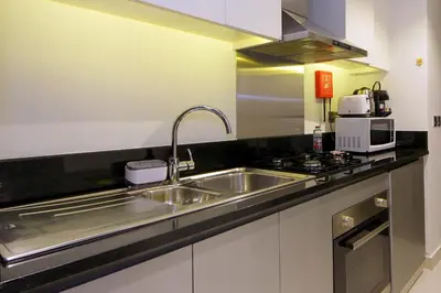 a kitchen with a sink and a stove at Cozy Studio in Damac Prive - Free Gym & Pool in Dubai