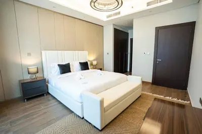 a bedroom with a large white bed and a table at Spacious Luxe 2BR in Dubai - With Pool and Gym in Dubai