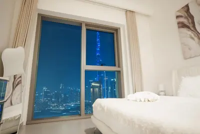 a bedroom with a window with a view of the city at Luxury2BR BurjKhalifa View Infinity Pool Mall Walk in Dubai