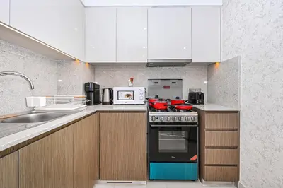 a kitchen with a stove and a microwave at Golden Stays - Sky High 2BR I Burj Khalifa Views & Mallside Charm I Dowtown Dubai in Dubai
