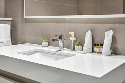 a bathroom sink with a white counter top at Golden Stays - Sky High 2BR I Burj Khalifa Views & Mallside Charm I Dowtown Dubai in Dubai