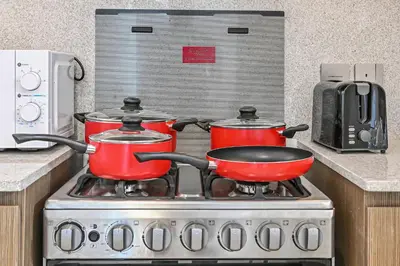 two pots and pans on a stove in a kitchen at Golden Stays - Sky High 2BR I Burj Khalifa Views & Mallside Charm I Dowtown Dubai in Dubai