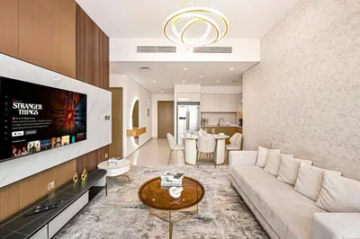a living room with a couch and a tv at Golden Stays - Sky High 2BR I Burj Khalifa Views & Mallside Charm I Dowtown Dubai in Dubai