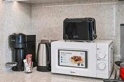 a microwave sitting on top of a kitchen counter at Golden Stays - Sky High 2BR I Burj Khalifa Views & Mallside Charm I Dowtown Dubai in Dubai