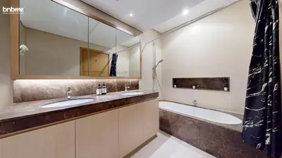 a bathroom with two sinks and a tub and a mirror at bnbmehomes - Vida Residence A1 in Dubai