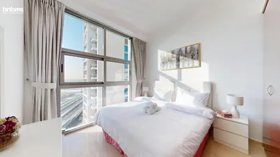 a bedroom with a white bed and a large window at bnbmehomes - DEC Tower 1 in Dubai