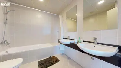 a bathroom with two sinks and a tub and a toilet at bnbmehomes - DEC Tower 1 in Dubai